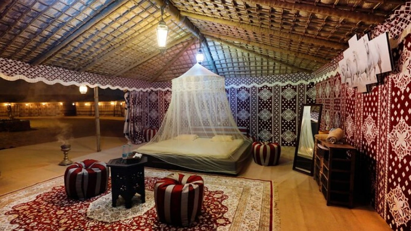 Dubai Bedouin camp dinner at night traditional Arabian tent campfire lanterns stars desert | roamvisa.com