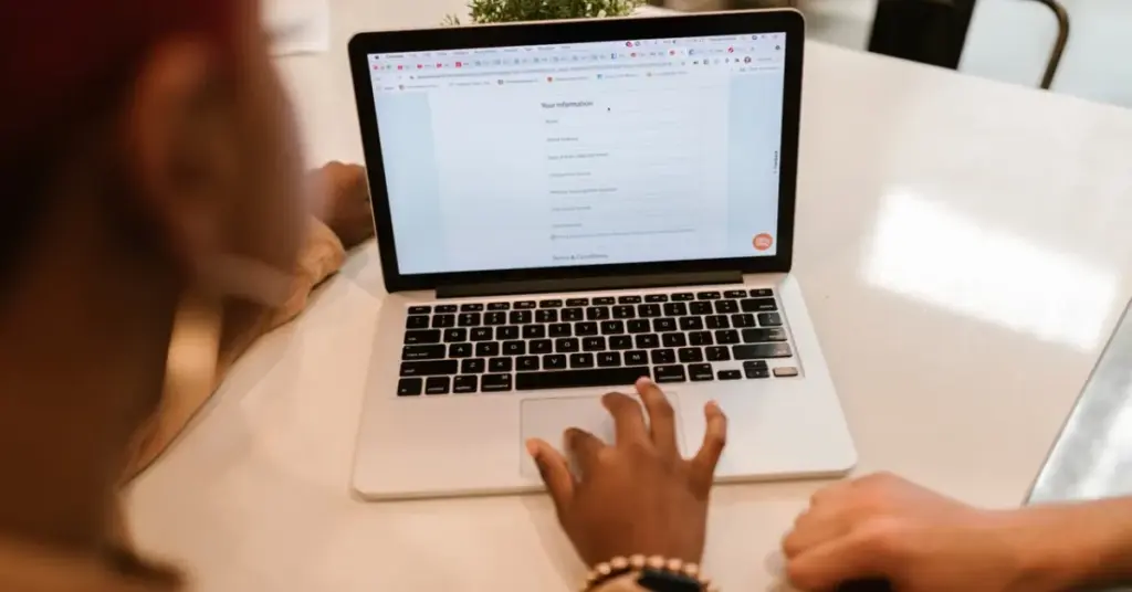 Person filling out a visa application form on a laptop Title