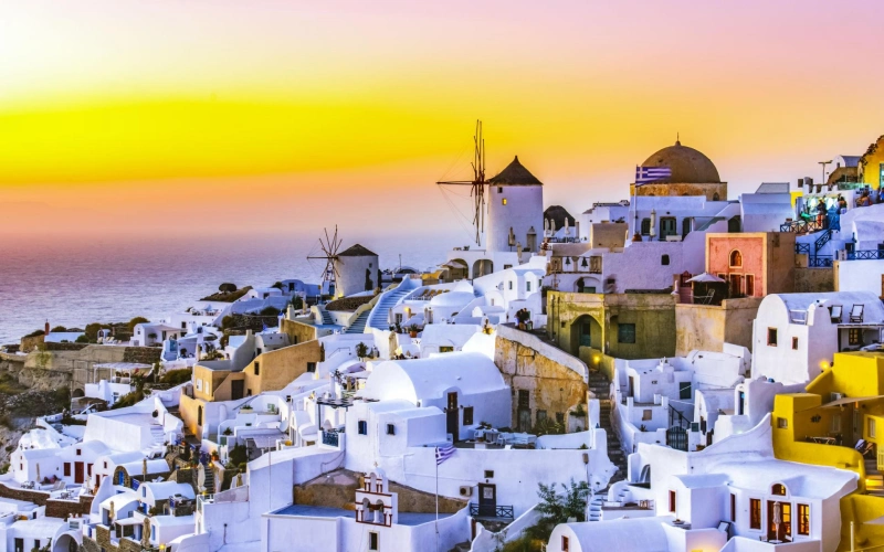 Santorini Greece Oia village sunset blue domes Aegean Sea romantic couple | roamvisa.com