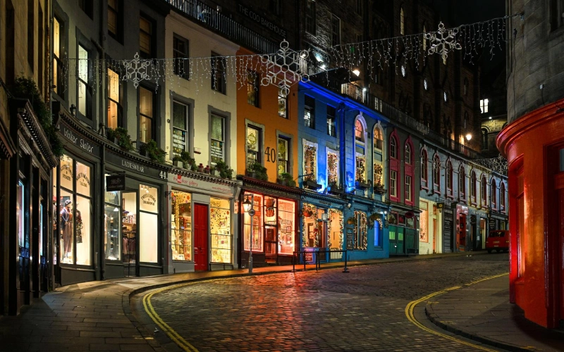Edinburgh romantic weekend couple walking Royal Mile at dusk castle on volcanic rock candlelit tenements  |  roamvisa.com