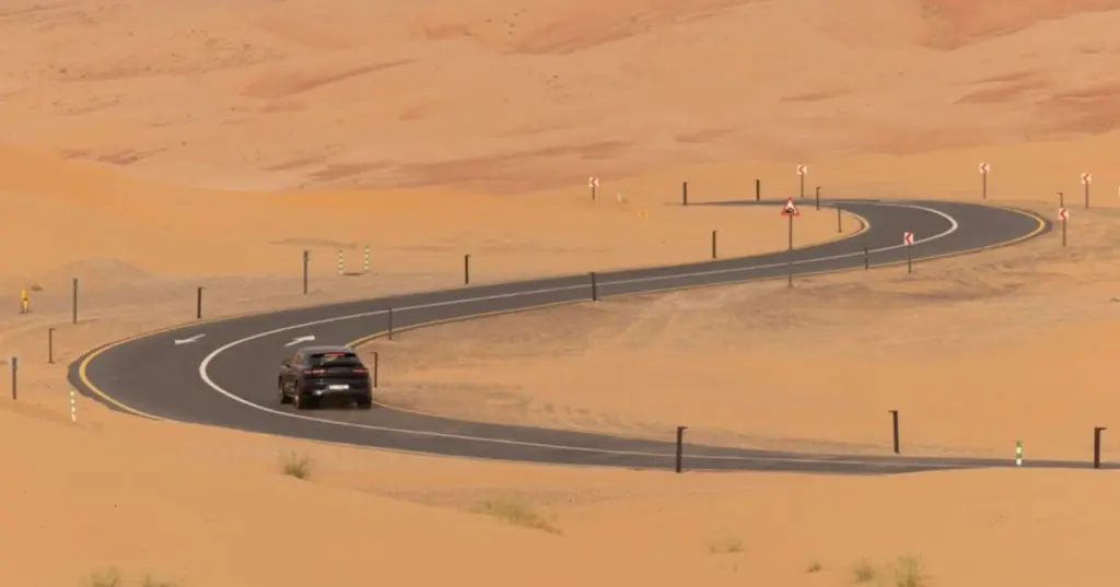 Hero image for the Dubai to Abu Dhabi road trip guide showing the E11 Sheikh Zayed Road with the Dubai skyline, representing the UAE's most popular intercity drive.