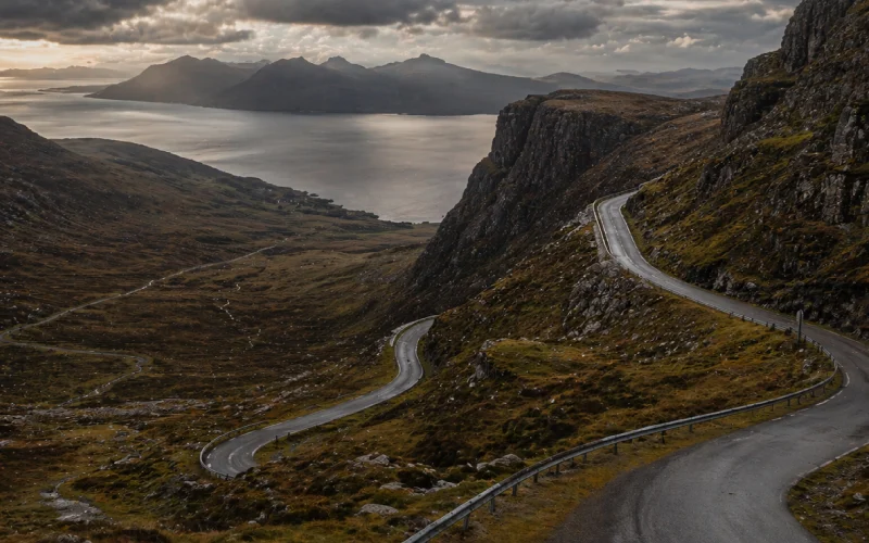 NC500 Bealach na Ba mountain pass Scotland hairpin bends single track road Isle of Skye visible in distanceNC500 Bealach na Ba mountain pass Scotland hairpin bends single track road Isle of Skye visible in distance