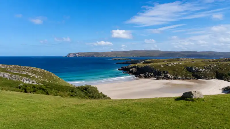 White sand crescent beach and clear water at Achmelvich Bay in the Scottish Highlands