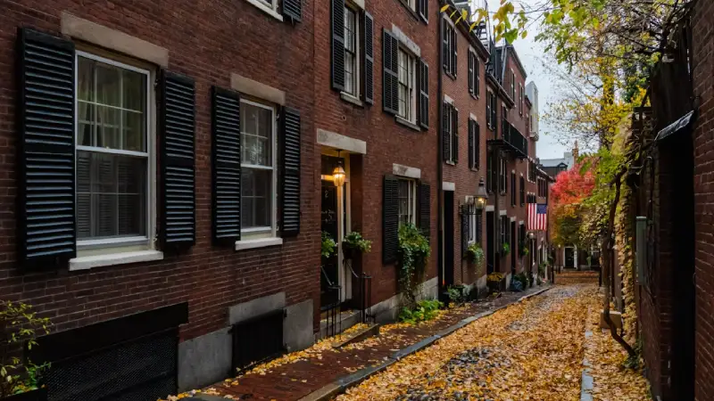 Brick rowhouses and gas lamps lining a street in Boston's Beacon Hill 