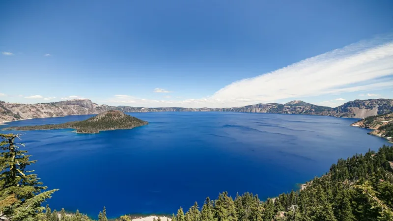 Deep blue water of Crater Lake surrounded by volcanic caldera walls in Oregon 