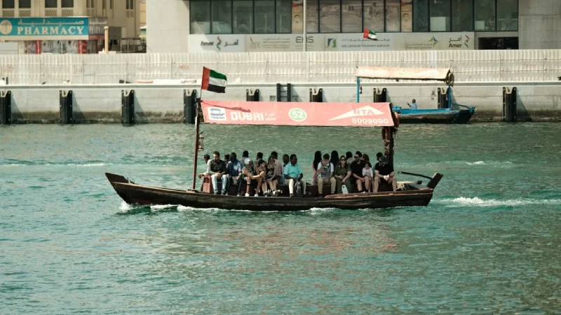 Traditional abra boat crossing Dubai Creek with the old city in the background
