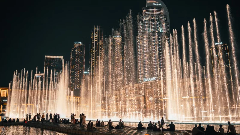 Dubai Fountain show lit up at night with Burj Khalifa in the background