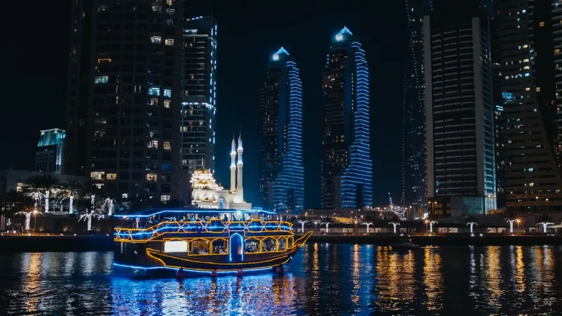 Traditional dhow cruise boat sailing along Dubai Marina in the evening 