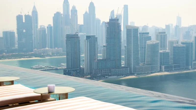 Hotel pool with a view of the Dubai skyline at a resort 