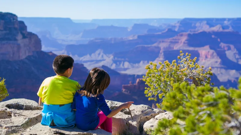Family with kids standing at a Grand Canyon viewpoint