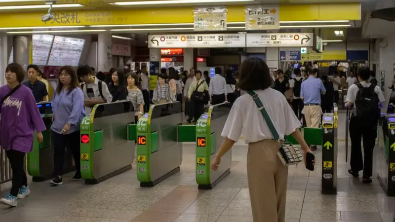 Traveler tapping an IC card at a train station gate in Japan