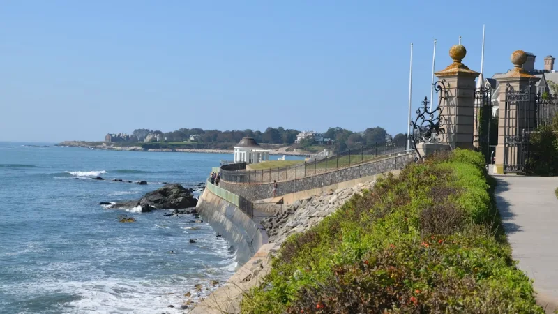 Cliff Walk path along the coast with a historic mansion in Newport Rhode Island 