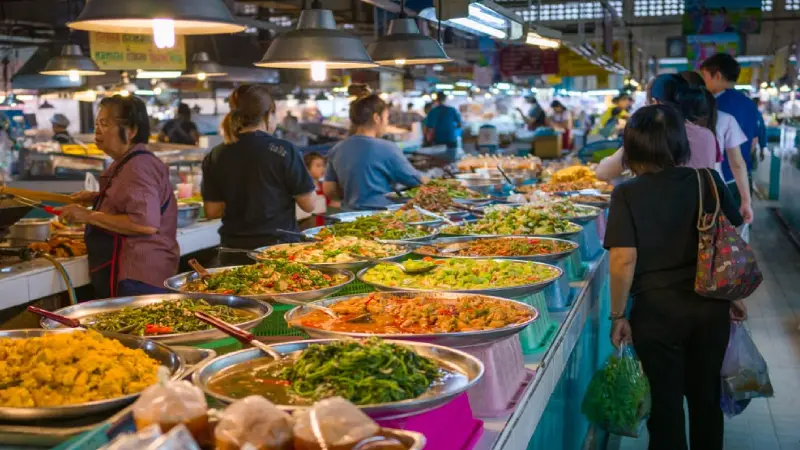 Street food vendor preparing Thai food at a market stall
