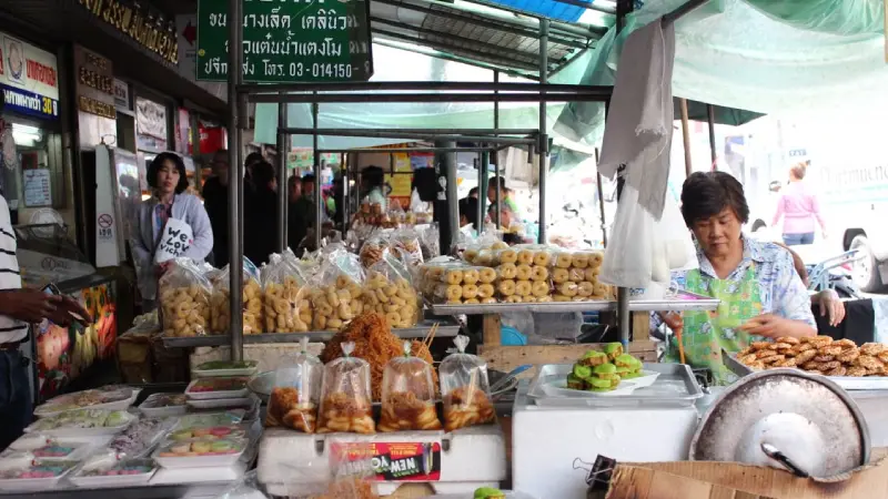 Street food vendor at a Thai market preparing food for customers
