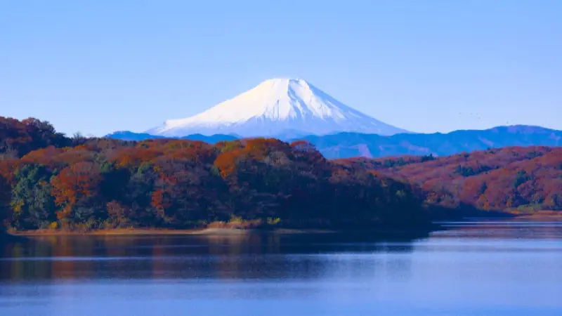Autumn foliage covering mountains around a lake in the Tohoku region of Japan