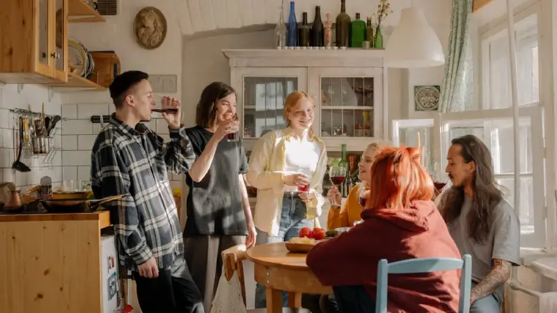Backpackers cooking together in a shared hostel kitchen