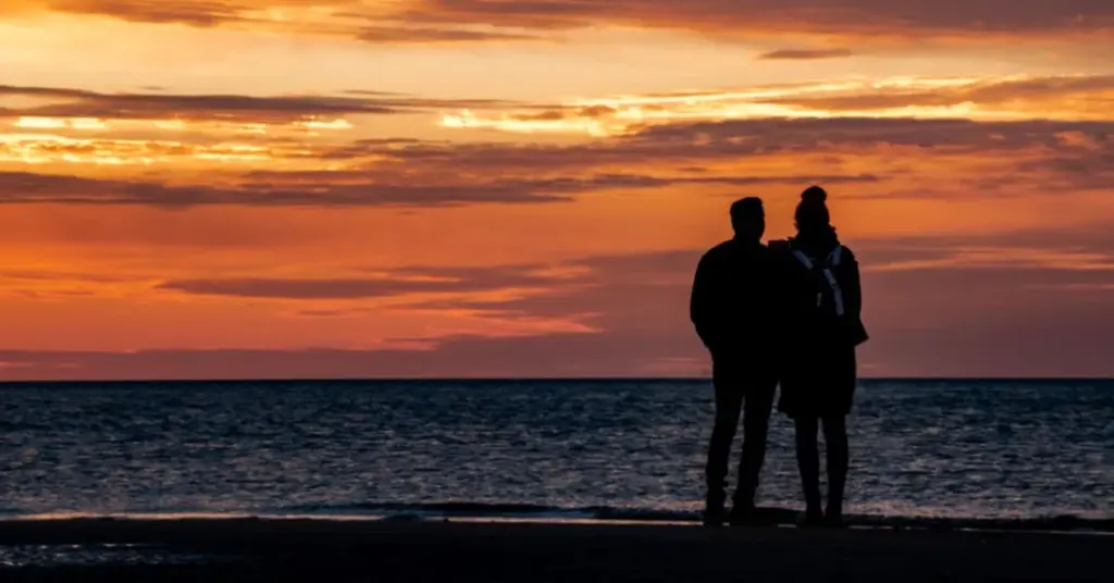 Couple watching the sunset together on a beach in Maui, Hawaii Best Honeymoon Destinations in USA