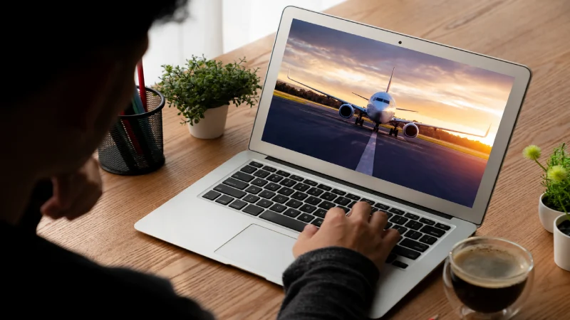 Person searching for flights on a laptop screen
