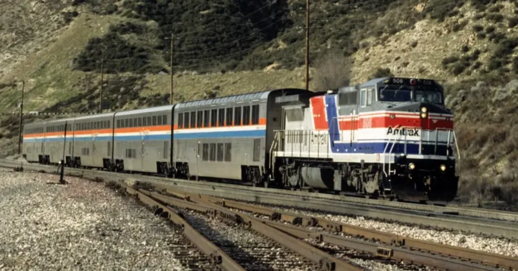 Amtrak Guide For Tourists An Amtrak train winding through a mountain landscape on a scenic US route