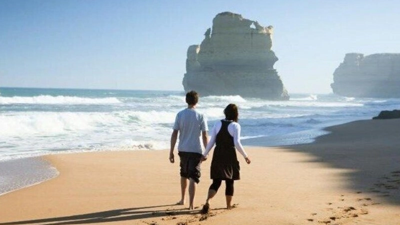 Couple looking out over the Twelve Apostles rock formations along the Great Ocean Road