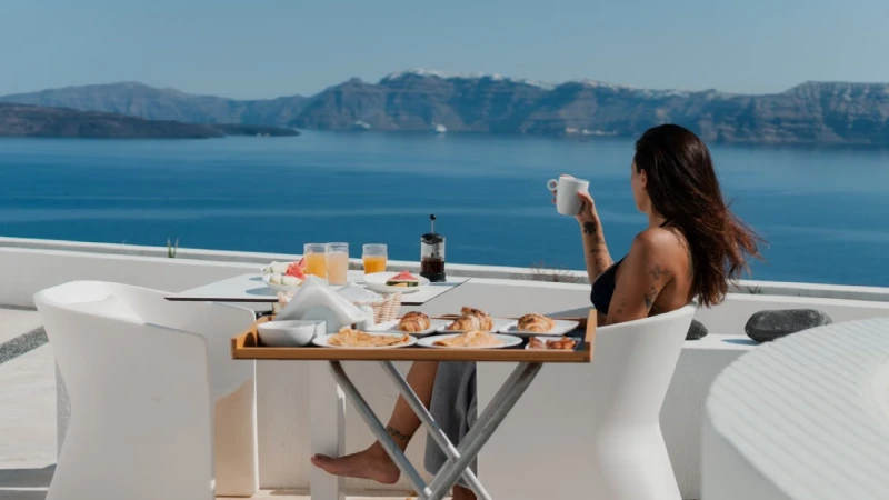 A couple relaxing on a caldera-facing hotel terrace in Santorini 