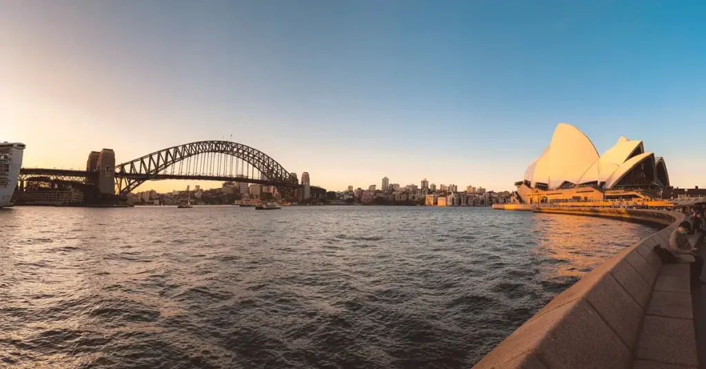 Best Time To Visit Australia And New Zealand Sydney Opera House and harbor lit up at sunset