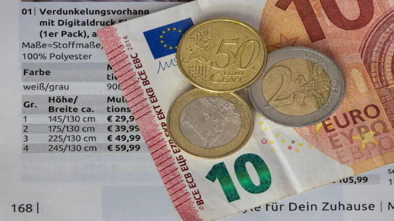 calculator and coins with world map travel insurance cost comparison