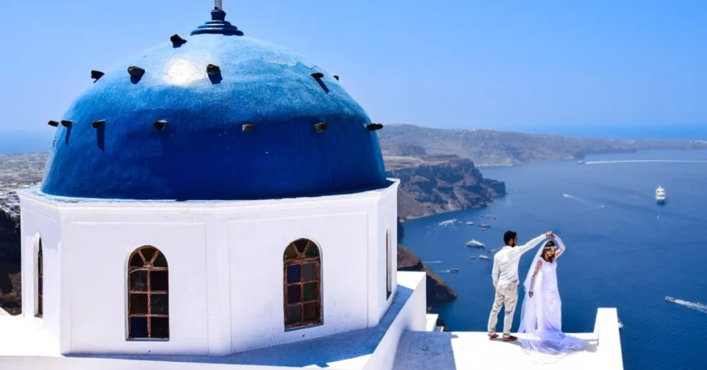 Couple watching the sunset over the caldera in Oia, Santorini