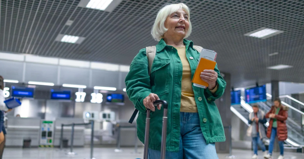 Best Travel Insurance For Elderly Travelers . Elderly traveler holding a passport and boarding pass at the airport