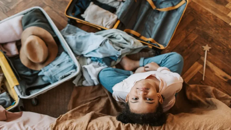 Family reviewing a travel checklist next to packed luggage