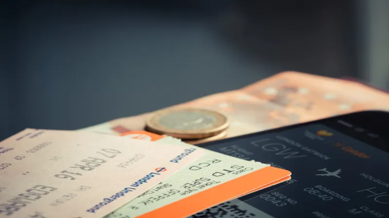Passport, boarding pass and travel documents laid out on a table