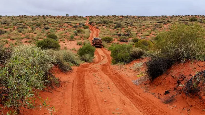 Four wheel drive vehicle on a red dirt road during an outback safari