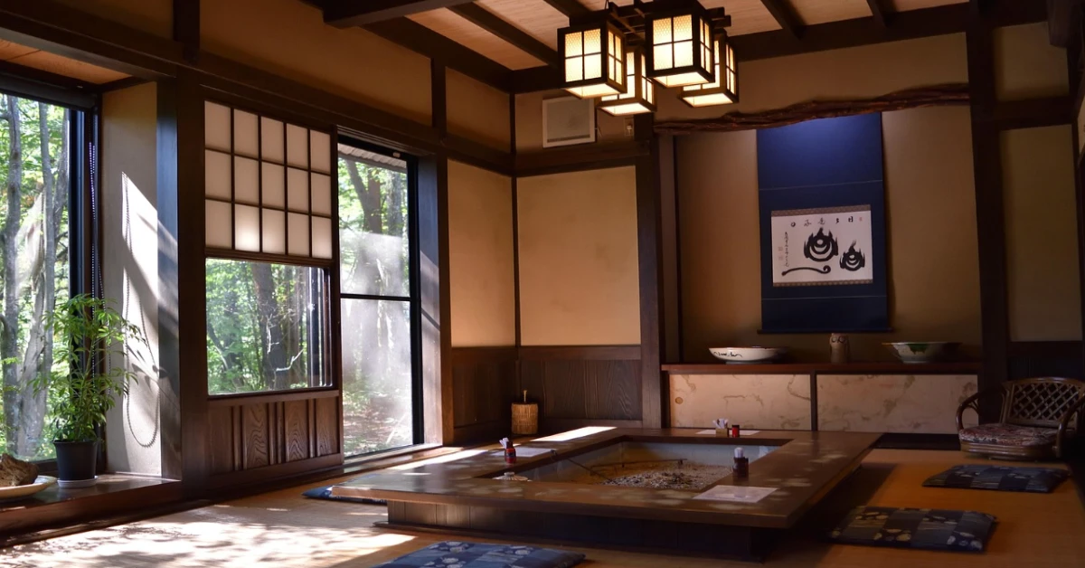 Ryokan vs Hotel Japan A traditional ryokan room with tatami flooring and a view toward an outdoor onsen
